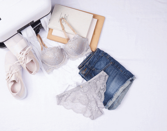 Small white luggage with ThirdLove's loungewear bag.