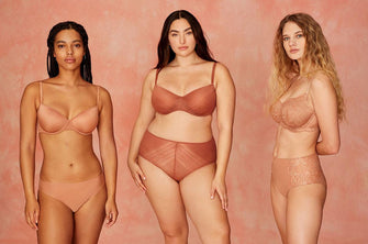 A group of three diverse women modeling ThirdLove's lace bras and underwear in warm sunset colors.