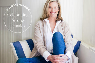True Botanicals Founder, Hillary Peterson, sitting on a couch with blue and white striped pillows.